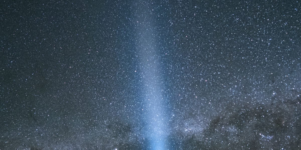 A lone figure gazing at a vast, awe-inspiring night sky, reflecting themes of cosmic dread.